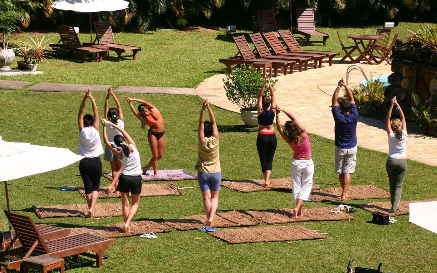 Itamambuca Eco Resort | Grupo com nove pessoas praticando yoga em um gramado no Itamambuca Eco Resort