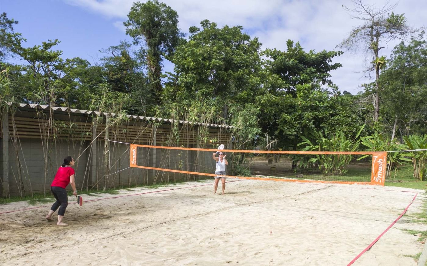 Resort | Duas pessoas jogando Beach Tennis na quadra de areia do Itamambuca Eco Resort